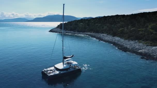 Vista de corte de cima, vista aérea deslumbrante de um barco flutuando em um belo mar azul-turquesa. — Vídeo de Stock