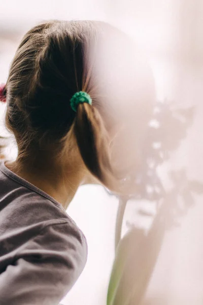 Mavi çiçeğin yanında baharın gelişini bekleyen küçük bir kız..