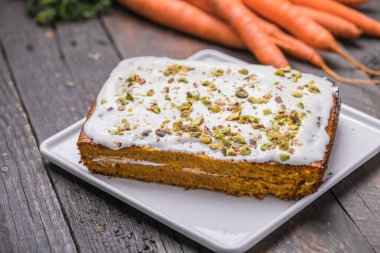 Tahta zemin üzerinde taze havuçlu bir havuçlu kek.