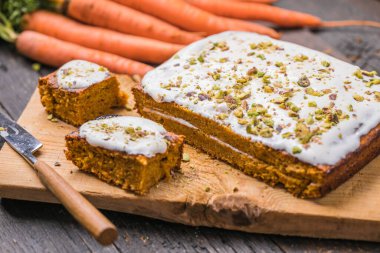 Tahta zemin üzerinde taze havuçlu bir havuçlu kek.