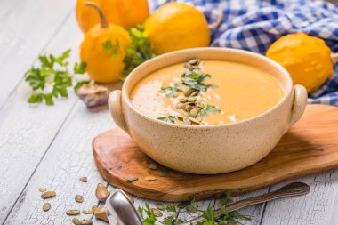 Beyaz ahşap masada kavrulmuş kabak tohumlu balkabağı çorbası, üst manzara, kopyalama alanı. Mevsimlik sonbahar yemekleri