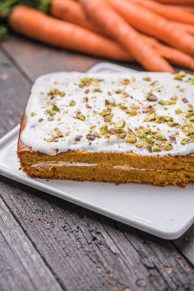 A  carrot cake with fresh carrot on wooden background