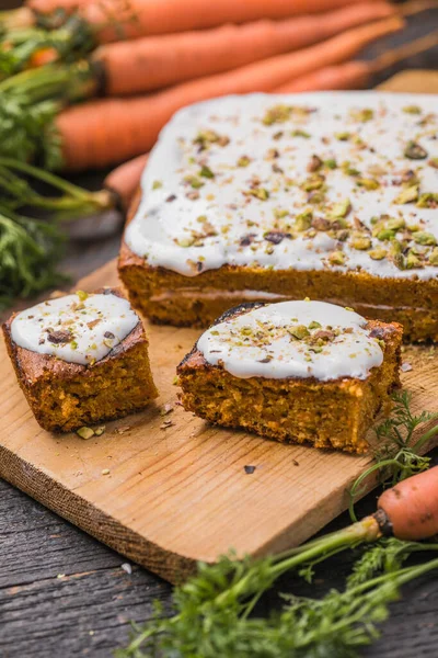 A  carrot cake with fresh carrot on wooden background