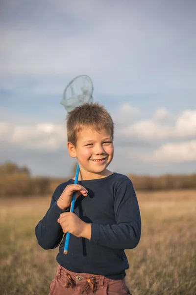 蝶のネットの牧草地を歩く若い男の子 子供が虫を捕まえる 子供の屋外のための季節の夏の活動 動物界の趣味を学ぶ — ストック写真
