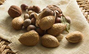 Fıstık, badem, masada ceviz. arkaplan saman ve eski bez