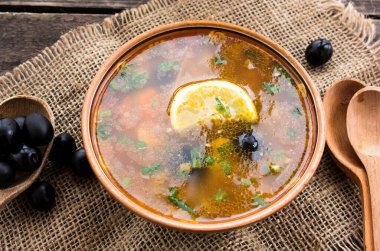 Solyanka - Rus geleneksel et çorbası, ulusal yemek çuval ve ahşap arka planda bir kaşık ile