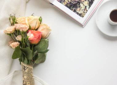 Güzel bir buket çiçek ve beyaz arka planda bir fincan çay.