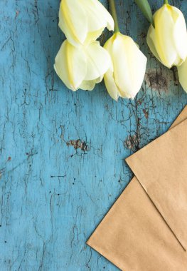 Mavi ahşap arka planda beyaz lalelerden oluşan çiçekler. Kopyalama alanı olan üst görünüm