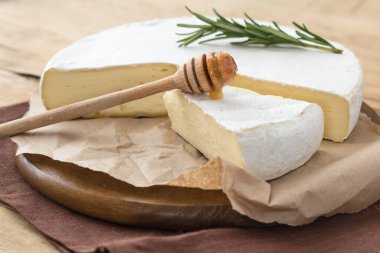 Brie peyniri ya da yumuşak inek dilimi - Fransız peyniri üzümlü, bal peteği ve cevizli ahşap panoda..