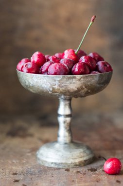 Gümüş kasede çiçekli donmuş kırmızı kiraz.