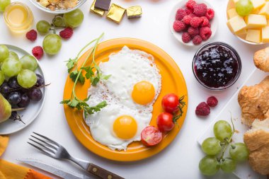 Sunny Side ile ev yapımı kahvaltı kızarmış yumurtalı kruvasan tostu kahve, sebze ve portakal suyu fotokopi alanı ile birlikte. Arka plan için nefis ev yapımı Amerikan kahvaltı konsepti