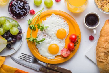 Sunny Side ile ev yapımı kahvaltı kızarmış yumurtalı kruvasan tostu kahve, sebze ve portakal suyu fotokopi alanı ile birlikte. Arka plan için nefis ev yapımı Amerikan kahvaltı konsepti