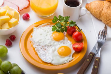 Sunny Side ile ev yapımı kahvaltı kızarmış yumurtalı kruvasan tostu kahve, sebze ve portakal suyu fotokopi alanı ile birlikte. Arka plan için nefis ev yapımı Amerikan kahvaltı konsepti
