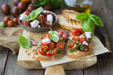 Domates, mozzarella peyniri ve fesleğen dilimleme tahtasında. Geleneksel İtalyan aperatifi veya aperatifi, antipasto.