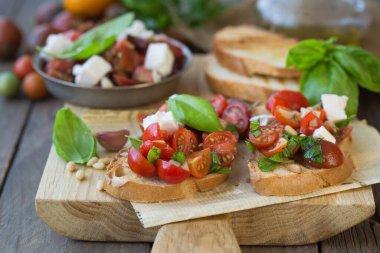 Domates, mozzarella peyniri ve fesleğen dilimleme tahtasında. Geleneksel İtalyan aperatifi veya aperatifi, antipasto.