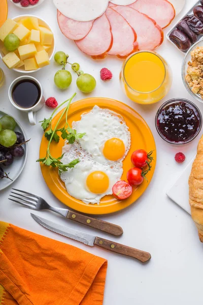 Sunny Side ile ev yapımı kahvaltı kızarmış yumurtalı kruvasan tostu kahve, sebze ve portakal suyu fotokopi alanı ile birlikte. Arka plan için nefis ev yapımı Amerikan kahvaltı konsepti