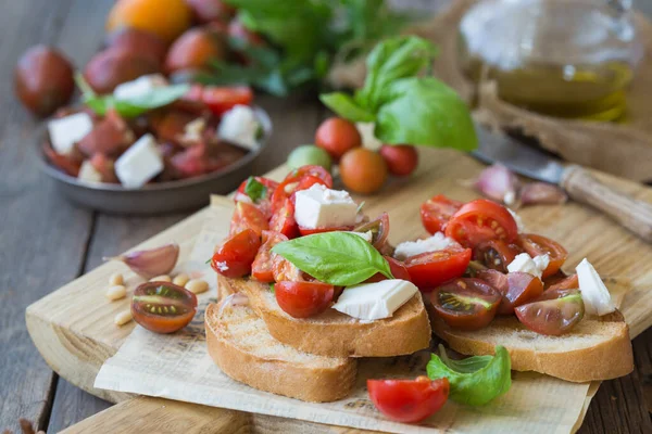 Domates, mozzarella peyniri ve fesleğen dilimleme tahtasında. Geleneksel İtalyan aperatifi veya aperatifi, antipasto.