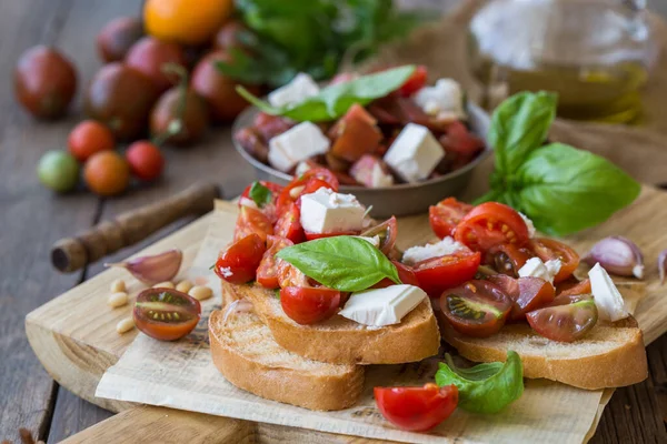 Domates, mozzarella peyniri ve fesleğen dilimleme tahtasında. Geleneksel İtalyan aperatifi veya aperatifi, antipasto.