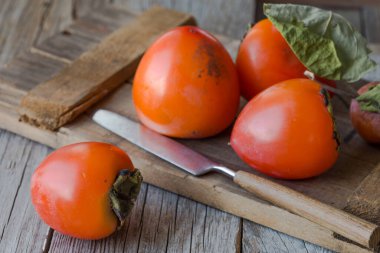 Olgun hurma ve ahşap arka planda dilimlenmiş. .