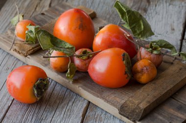 Olgun hurma ve ahşap arka planda dilimlenmiş. .