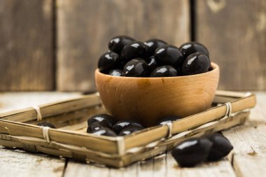 Kırsal arka planda tahta kaselerde zeytinler