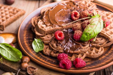 Krema ve taze böğürtlenli gofretler beyaz arka planda çikolata serpiştirilir. Üst görünüm, boşluğu kopyala. Ev yapımı Belçika Waffle 'ları