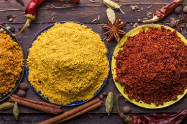 Ahşap arka planda çeşitli zemin baharatları var. Gürcü baharatları, Hint baharatları, Arap baharatları. Baharat çeşitliliği. Bitkiler ve baharatlar. Katman, siyah.