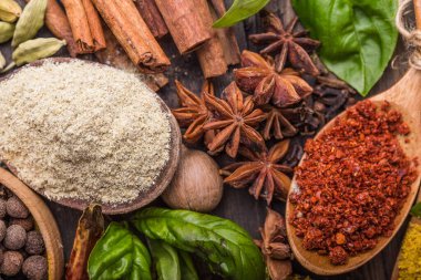 Ahşap arka planda çeşitli zemin baharatları var. Gürcü baharatları, Hint baharatları, Arap baharatları. Baharat çeşitliliği. Bitkiler ve baharatlar. Katman, siyah.