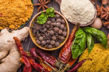 Ahşap arka planda çeşitli zemin baharatları var. Gürcü baharatları, Hint baharatları, Arap baharatları. Baharat çeşitliliği. Bitkiler ve baharatlar. Katman, siyah.