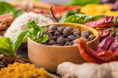 Ahşap arka planda çeşitli zemin baharatları var. Gürcü baharatları, Hint baharatları, Arap baharatları. Baharat çeşitliliği. Bitkiler ve baharatlar. Katman, siyah.