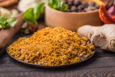 Ahşap arka planda çeşitli zemin baharatları var. Gürcü baharatları, Hint baharatları, Arap baharatları. Baharat çeşitliliği. Bitkiler ve baharatlar. Katman, siyah.