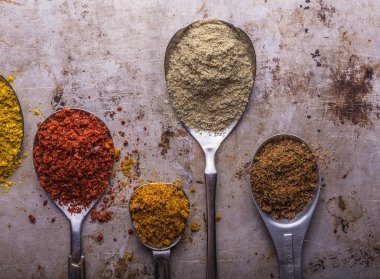 Ahşap arka planda çeşitli zemin baharatları var. Gürcü baharatları, Hint baharatları, Arap baharatları. Baharat çeşitliliği. Bitkiler ve baharatlar. Katman, siyah.