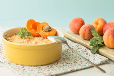 Tahta bir masada taze kayısı ve nane yapraklı kabak püresi.