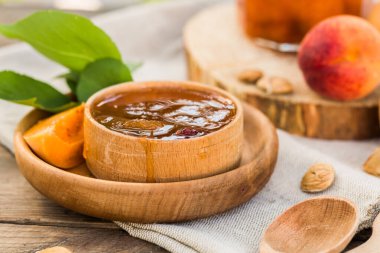 şeftali reçeli, cam bir kavanozda, tahta bir masada.