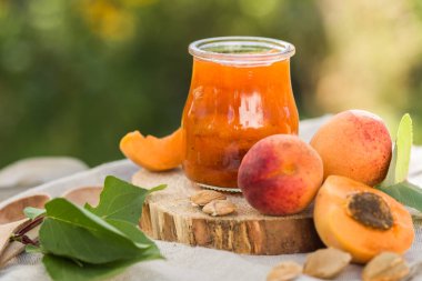 Şeftali reçeli bir bardakta, tahta bir masada.