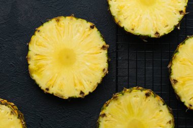 Gri arkaplanda dilimlenmiş olgun ananas