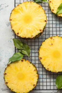 Gri arkaplanda dilimlenmiş olgun ananas