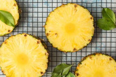 Gri arkaplanda dilimlenmiş olgun ananas