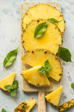 Gri arkaplanda dilimlenmiş olgun ananas