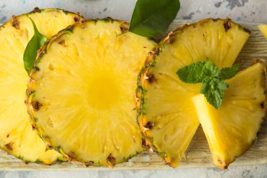 Gri arkaplanda dilimlenmiş olgun ananas
