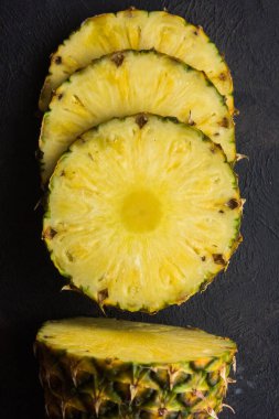 Gri arkaplanda dilimlenmiş olgun ananas