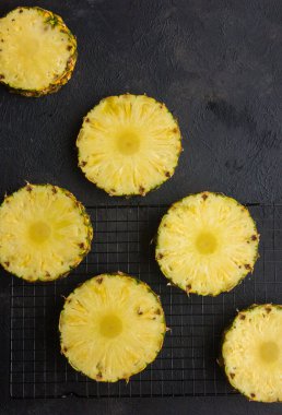 Gri arkaplanda dilimlenmiş olgun ananas