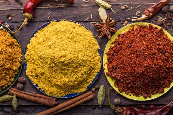 Ahşap arka planda çeşitli zemin baharatları var. Gürcü baharatları, Hint baharatları, Arap baharatları. Baharat çeşitliliği. Bitkiler ve baharatlar. Katman, siyah.