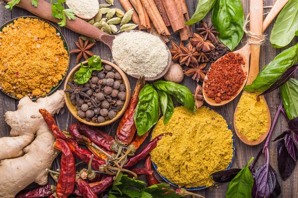 Ahşap arka planda çeşitli zemin baharatları var. Gürcü baharatları, Hint baharatları, Arap baharatları. Baharat çeşitliliği. Bitkiler ve baharatlar. Katman, siyah.