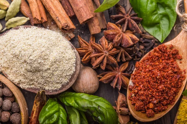 Ahşap arka planda çeşitli zemin baharatları var. Gürcü baharatları, Hint baharatları, Arap baharatları. Baharat çeşitliliği. Bitkiler ve baharatlar. Katman, siyah.