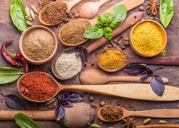 Ahşap arka planda çeşitli zemin baharatları var. Gürcü baharatları, Hint baharatları, Arap baharatları. Baharat çeşitliliği. Bitkiler ve baharatlar. Katman, siyah.