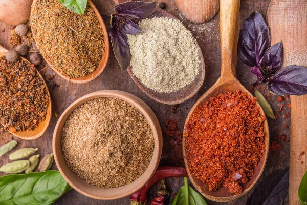 Ahşap arka planda çeşitli zemin baharatları var. Gürcü baharatları, Hint baharatları, Arap baharatları. Baharat çeşitliliği. Bitkiler ve baharatlar. Katman, siyah.