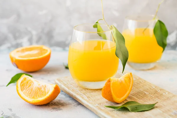 新鮮なオレンジジュース 熟したオレンジ色の果物と素朴な木製のテーブルの上のスライスのガラス 絞りたてのオレンジジュース — ストック写真
