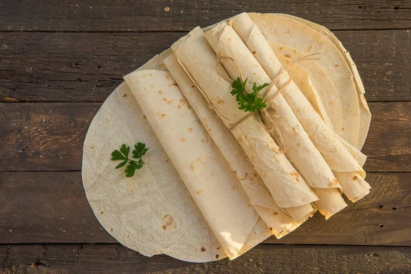 Armenian flat bread lavash. Pita bread on wooden background. Copy space. Top view or flat-lay.