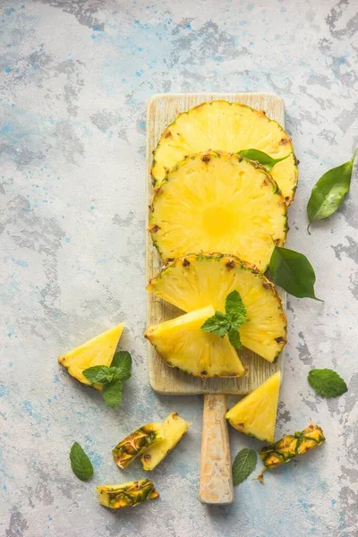 Gri arkaplanda dilimlenmiş olgun ananas